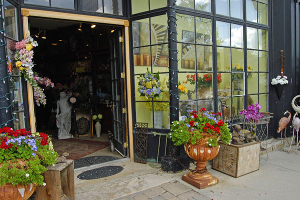 flowers in urns frame the entrance to shop in Elora