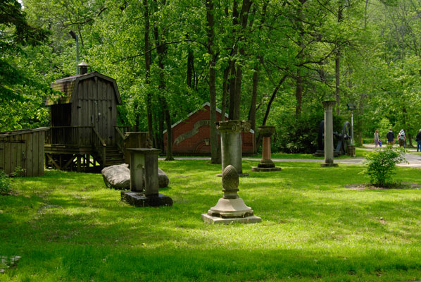 a view of a lawn with columns and architectural fragments